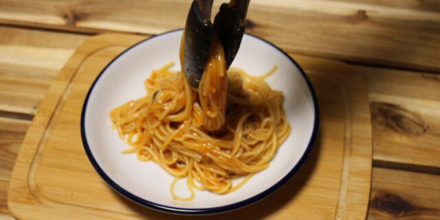 白い皿にパスタを盛りつける